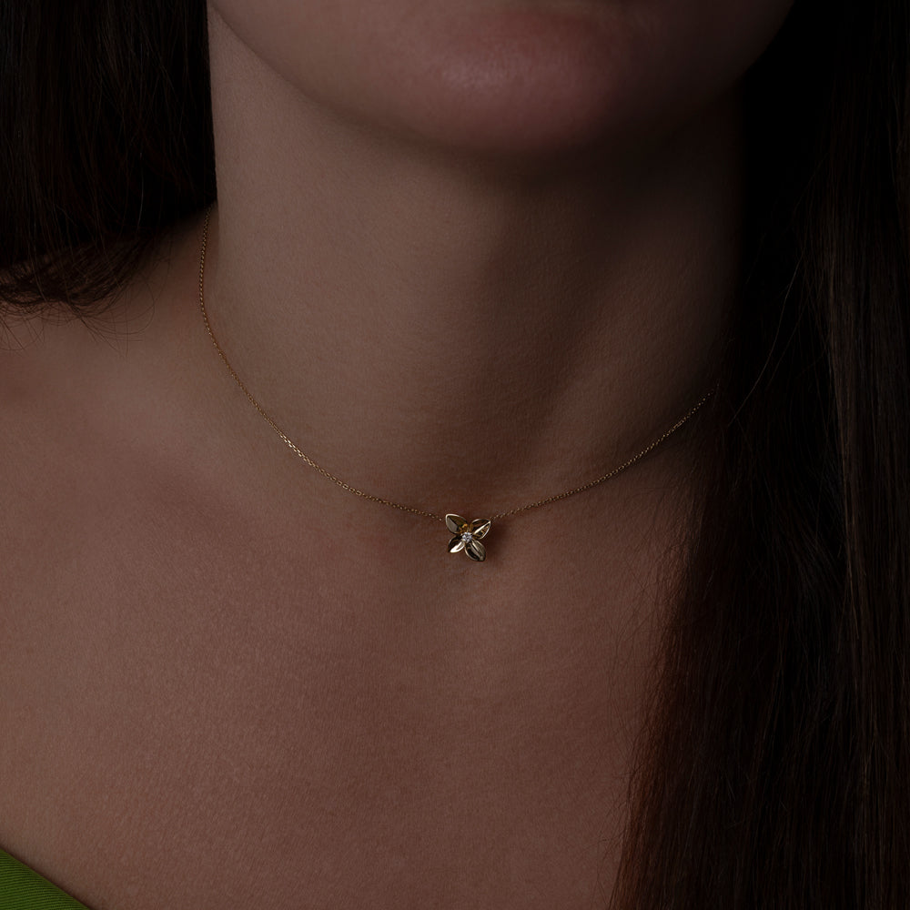 Gold flower necklace with diamond center on model