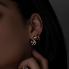 Gold and diamond flower earring stack on model